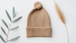 © Narongsag - Beige Knitted Hat with Eucalyptus and Pampas Grass on White Background