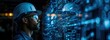 © Алина Бузунова - A digital collage of industrial designs and sketches, with an engineer in the foreground wearing a hard hat looking at holographic projections of buildings or machinery