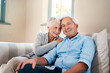 © Malambo/peopleimages.com - Smile, portrait and senior couple on sofa for connection, bonding and relaxing together at home. Happy, love and elderly man and woman hugging for resting in living room at house in Switzerland.