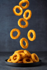 Wall Mural -  Fried onion rings with mozzarella or plain. Delicious onion rings on black background