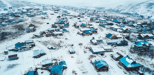 Aerial view of a small village covered in snow, with houses scattered across the landscape.