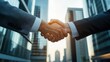 © Stone Story - Two business professionals shaking hands outside modern office buildings, signifying partnership and agreement.