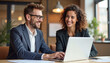 © PREM - Happy professional business man and woman working on laptop at office meeting, two busy colleagues working together having conversation on project, discussing business plan at office