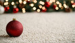 © javu - A vibrant red Christmas ornament rests on a soft carpet, with a beautifully lit holiday tree in the background.