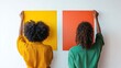 © lulu Alana - Two curly hair people are hanging up two color swatches on the wall on a white background.