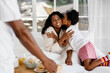 © (JLco) Julia Amaral - Young daughter kissing mother during breakfast in bed