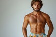 © Gatherina - Handsome muscular man with a beard posing in swim trunks