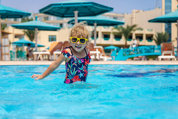 Poster - Child playing in the pool. Selective focus.