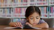 © FAMILY STOCK - An Asian girl is reading a book in a library, looking serious as she focuses on the contents.