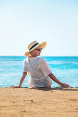 Wall Mural - Woman in a hat on the seashore. Selective focus.