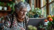 © เลิศลักษณ์ ทิพชัย - An elderly woman using a laptop at home, staying connected with family and learning new skills.