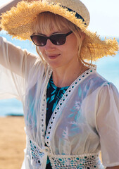 Wall Mural - Woman in a hat on the seashore. Selective focus.