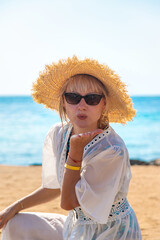 Wall Mural - Woman in a hat on the seashore. Selective focus.