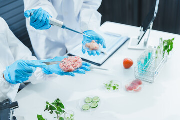 two asian women in a lab work on food research, using a microscope, petri dish, and test tubes fille