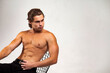 © Alex Vog - Sporty perfect guy fashion model with perfect sexy naked torso posing sitting on chair, serious looking away. Stylish muscular man with muscles abs press on white studio background. Copy ad text space