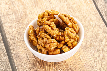 Cracked unshelled walnut in the bowl