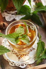 Canvas Print - A cup of herbal tea with fresh stinging nettles