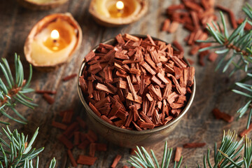 Wall Mural - Red sandalwood chips in a bowl with Christmas candles and spruce tree branches