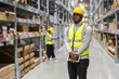 © Art_Photo - Portrait of smiling african american engineer man order details on tablet checking goods and supplies on shelves with goods background in warehouse.logistic and business export