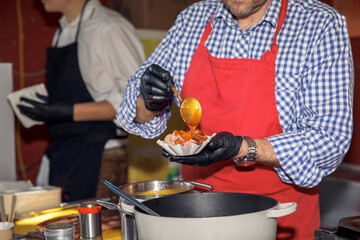 Chef preparing street food, man wearing apron, cooking at food stall, culinary, street food, vendor, food preparation, market, food business, food preparation concept