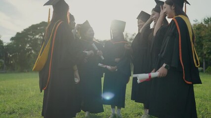 Wall Mural - A group of women in graduation gowns are standing in a field. They are smiling and holding their graduation certificates