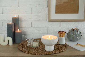 Wall Mural - Burning candles and decor on table near white brick wall