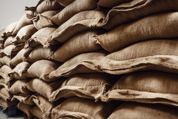 Jute Bags Filled With Fresh Green Coffee Beans Stacked in a Warehouse Ready for Processing and Distribution