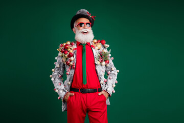 Sticker - Photo of funny white hair santa man look empty space confident wear balls baubles on jacket sunglass hat isolated on green color background