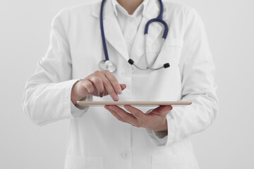 Wall Mural - Doctor with tablet on white background, closeup view