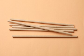 Poster - Bamboo drinking straws on beige background, top view