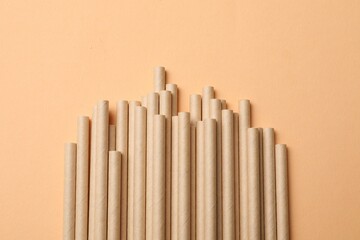 Wall Mural - Bamboo drinking straws on beige background, top view