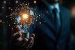© oksa_studio - Businessman holding light bulb connected with network concept for idea innovation and inspiration