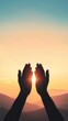 © pornchan - Silhouette of hands raised in prayer against a glowing sunset, light radiating divine grace