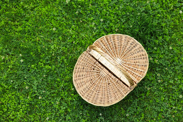 Wall Mural - One picnic wicker basket on green grass, top view. Space for text