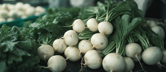 A close-up image of freshly harvested white turnips piled in a crate, showcasing their natural, slightly dirty texture.
