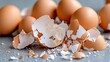 © Pinklife - A collection of broken brown eggshells is scattered over a flat surface, representing fragility, the remnants of used eggs, highlighting the concept of lifecycle.