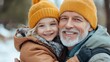 © Pinklife - A joyful elderly man in a winter hat holds his smiling granddaughter in a similar hat, both dressed warmly, showcasing loving family bonds in a winter setting.