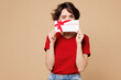 © ViDi Studio - Young happy woman she wears red t-shirt casual clothes hold cover eye with gift certificate coupon voucher card for store isolated on plain pastel beige background studio portrait. Lifestyle concept.