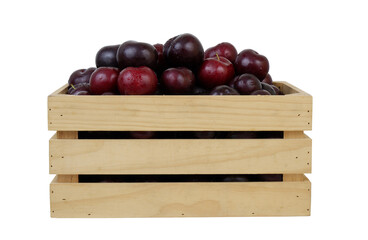 Wall Mural - Many ripe plums in wooden box isolated on white background	