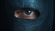 © ART IS AN EXPLOSION. - A person's eye is visible through a black mask
