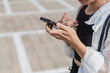 © wdnld - Young Woman Using Smart phone in Parking Lot
