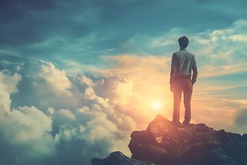 Poster - Silhouette of man standing on mountaintop facing the sunset, a powerful image representing hope, ambition, and success