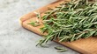 © nunne - Detailed image of dried rosemary sprigs on a chopping board, dried rosemary, culinary herbs and natural flavoring