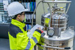 © reewungjunerr - Asian engineer working at Operating hall,Thailand people wear helmet  work,He worked with diligence and patience,she checked the valve regulator at the hydrogen tank.