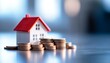 © Lightgeo - A model house with stacks of coins, symbolizing real estate investment and financial growth for homeowners and investors.