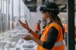 © Mikhail Vorobev - Woman in safety vest uses vr glasses to showcase construction site with digital building models