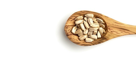 Poster - Shelled sunflower seeds in a wooden spoon set against a white background. Copy space image. Place for adding text and design