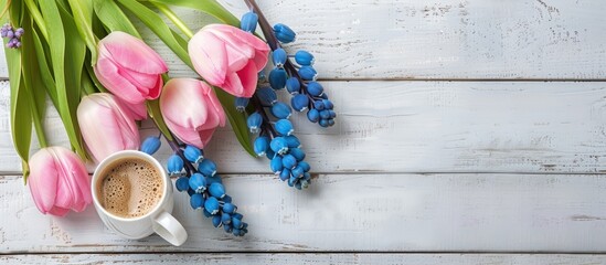 Canvas Print - Pink tulips and blue hyacinth flowers alongside a cup of coffee for Valentine s Day on a white wooden table with copy space available