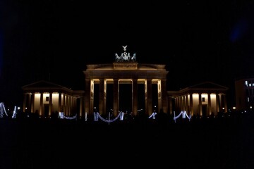 The Brandenburg Gate stands illuminated, a beacon of historical significance and a testament to Berlin's journey from division to unit