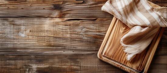 Wall Mural - Empty wooden cutting board with a kitchen cloth on a wooden background. Copy space image. Place for adding text and design